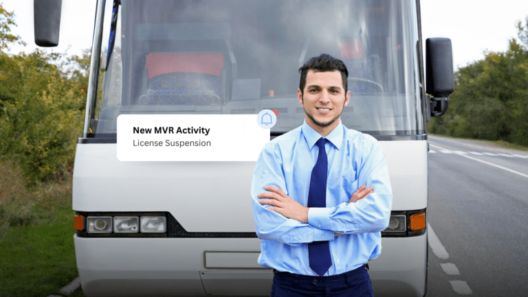 A man in a blue shirt and tie stands confidently with arms crossed in front of a bus on the road. A notification next to him reads, New MVR Activity: License Suspension, emphasizing the importance of driver compliance in maintaining safe transportation.